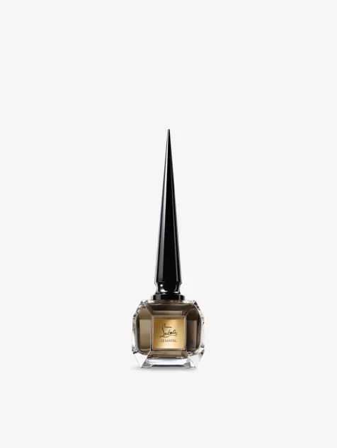 Faceted clear bottle with brown fluid and tall pointed black cap of  Christian Louboutin  Fétiche le Santal eau de parfum